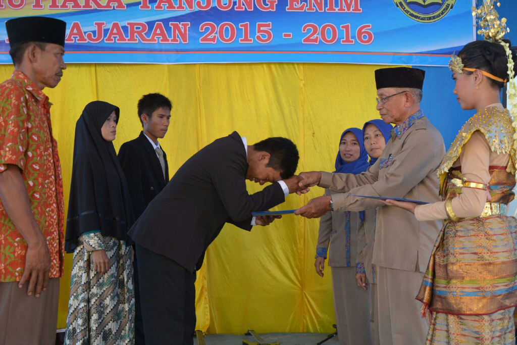 Kepala SMK Mutiara H. Rasman, A.Mk saat menyerahkan siswa-siswi secara simbolis kepada orang tuanya