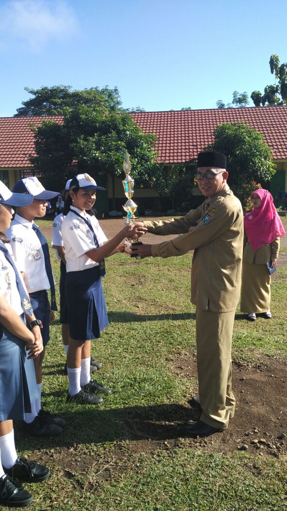 Kepala SMP N 3 Tanjung Agung saat menyerahkan piala kepada siswa berprestasi
